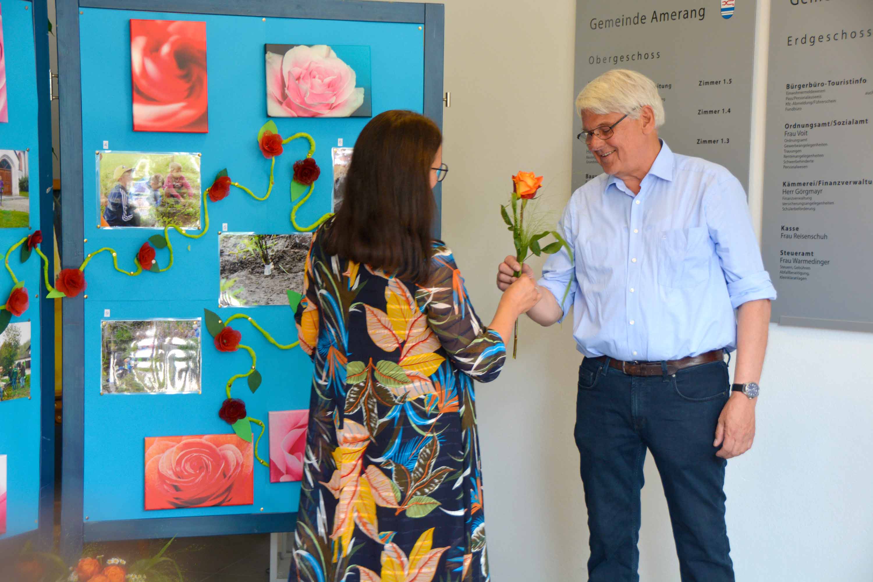 Der Rosenweg wird er&ouml;ffnet. Da m&uuml;ssen Rosen &uuml;bereicht weden. Auf den Stellw&auml;nden sieht man Bilder, die die Kinder zum Thema angefertigt haben.